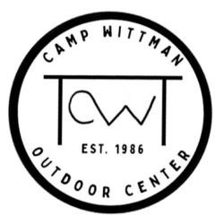 Purpose of this image is to display the new Camp Wittman Outdoor Center as of 2025. Updated logo for Camp Wittman Outdoor Center as of 2025: Bold black circle on white background contains the words "Camp Wittman Outdoor Center" and "Est. 1986", as well as line art shose shape suggests the iron entry gate with its iron "CW"